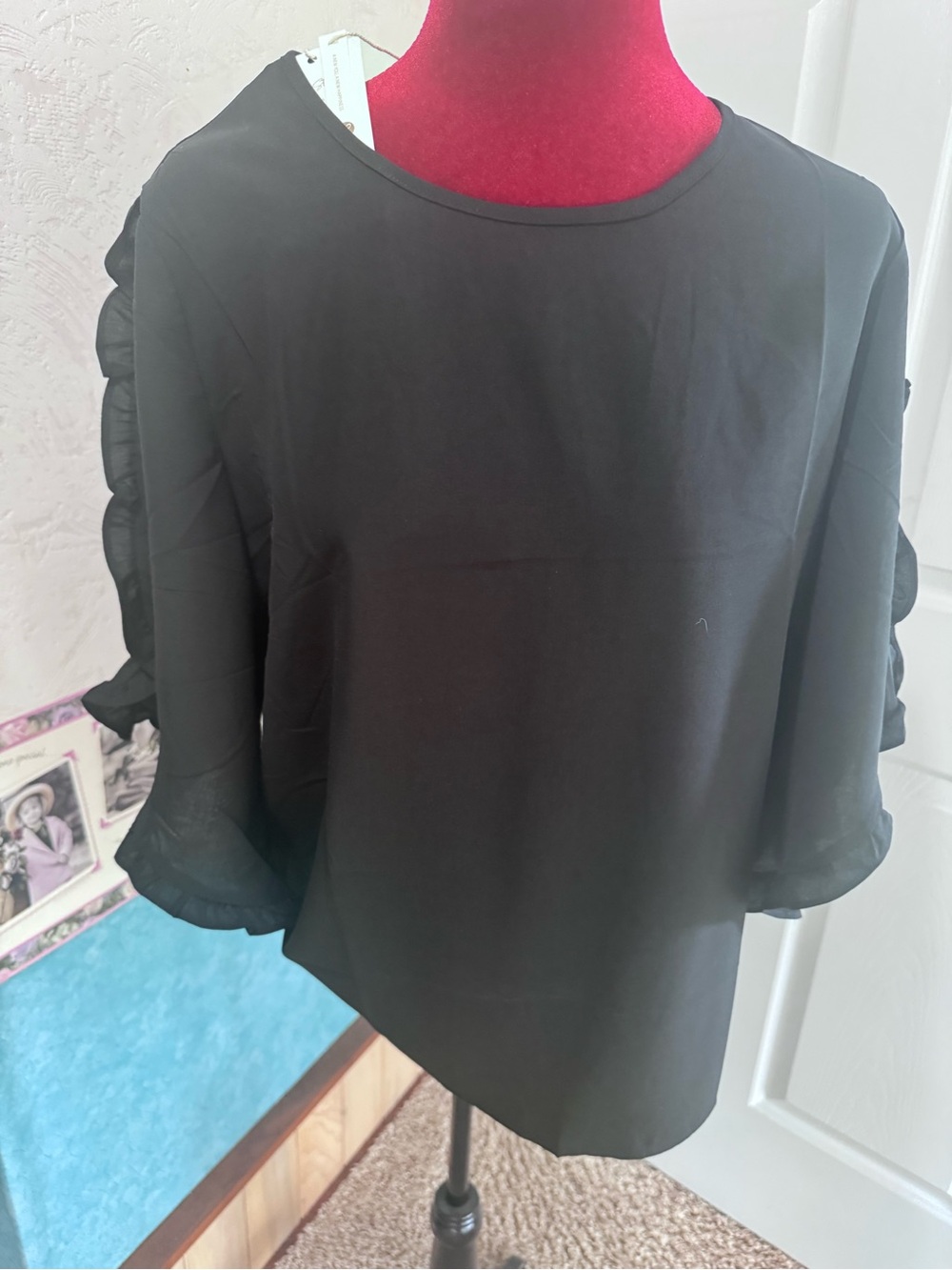Black blouse. Ruffle on sleeve. Missing back button. NWT